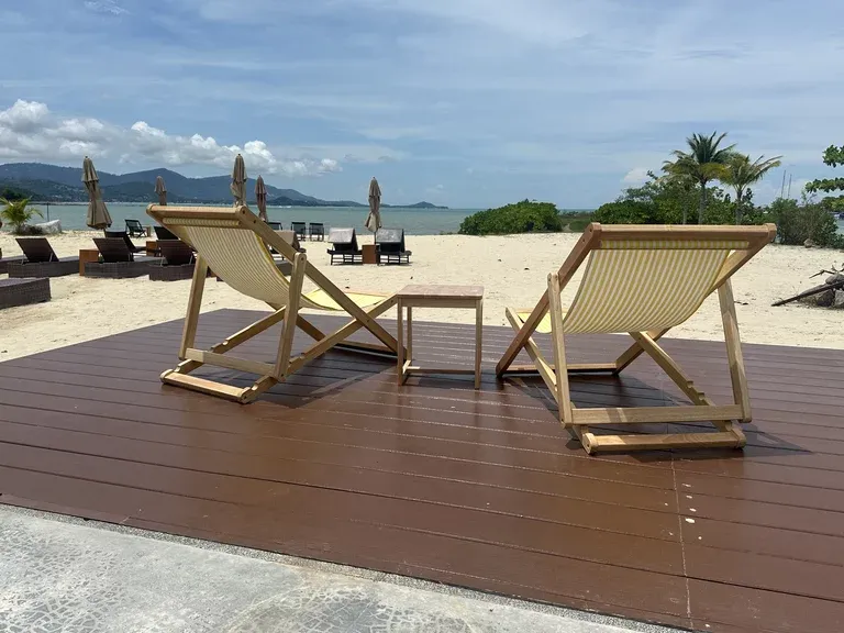 Holzdeck mit Liegen über der Bucht von Ko Samui